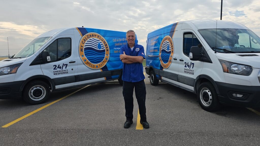 Owner of My Calgary Plumber standing in front of branded service vans in Calgary, providing trusted residential plumbing services.